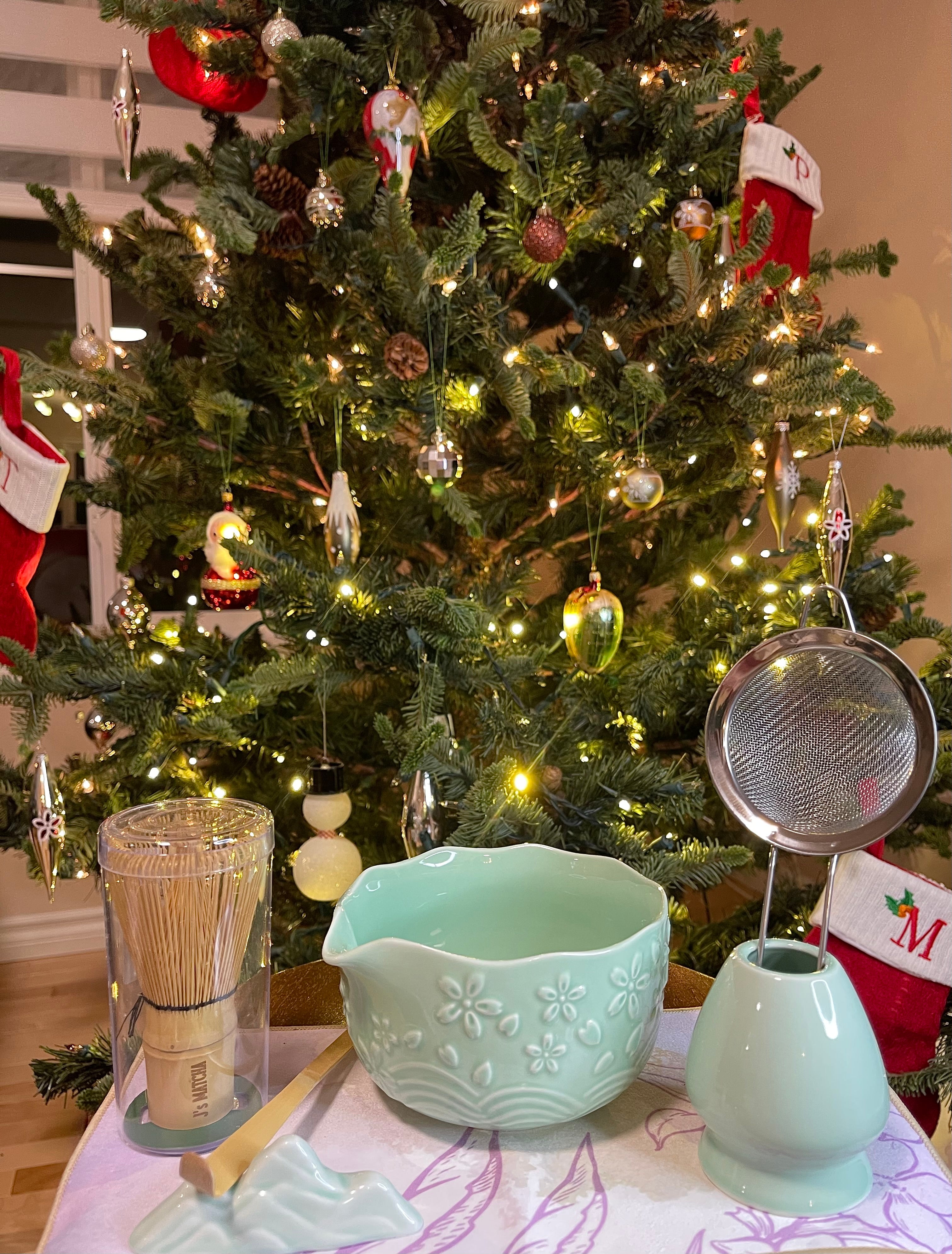Decorative items on a table in front of a Christmas tree