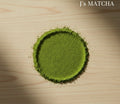 Matcha powder in a circular shape on a wooden surface with 'J's Matcha' branding.